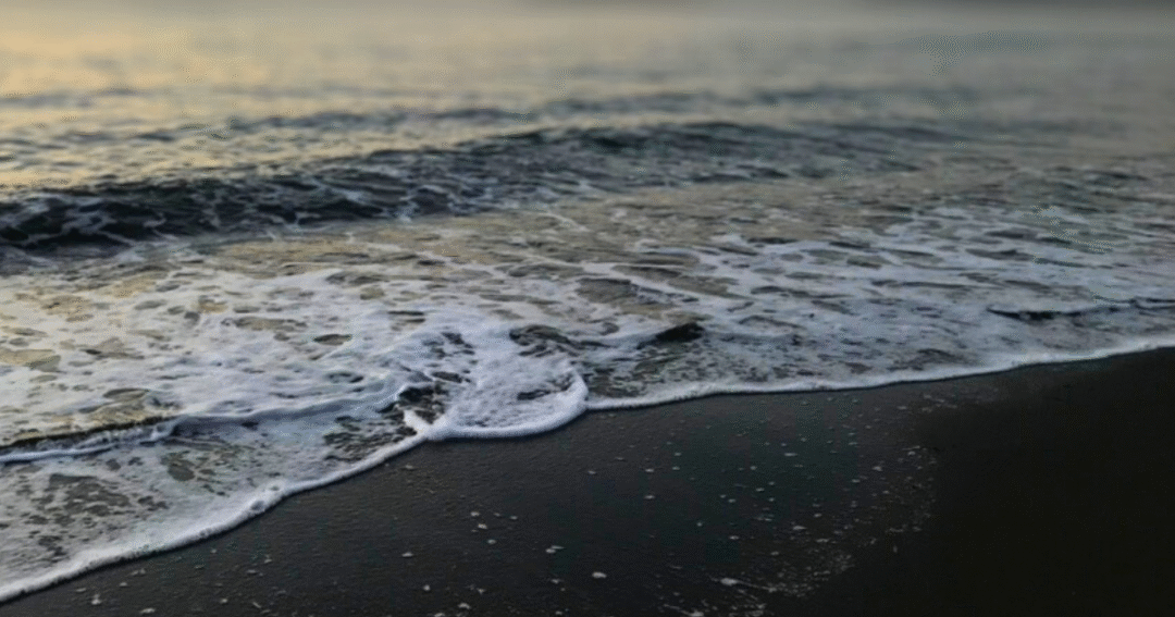 夕暮れ後の静かな海辺。やわらかな波が寄せ、夜の始まりをやさしく告げている。