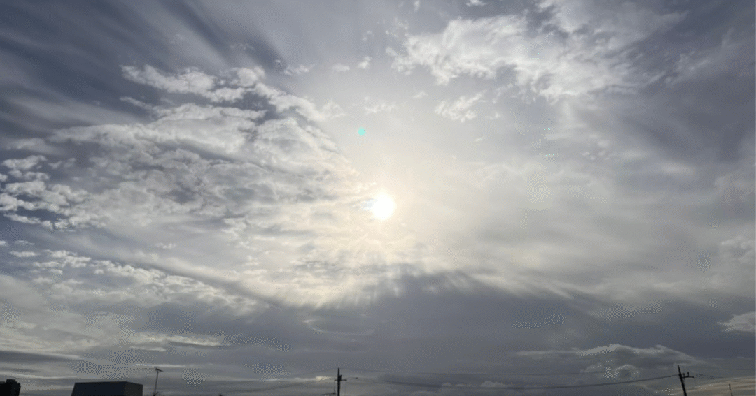 雲のすき間から差し込む光が放射状に広がる空。過去を抱えながらも、未来へ一歩踏み出す希望を映した景色。