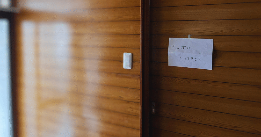 玄関の壁にそっと貼られた「さんぽに いってきます」の張り紙。外へ出る練習を見守る、小さな一歩を写した写真🌿