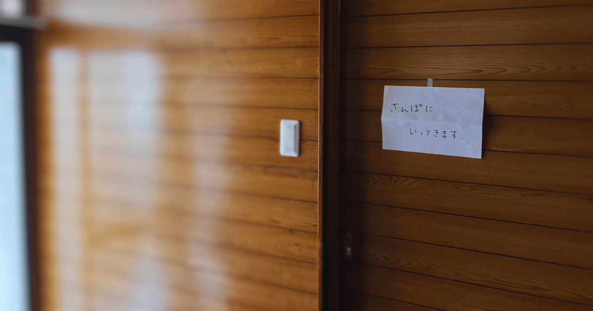 玄関の壁にそっと貼られた「さんぽに いってきます」の張り紙。外へ出る練習を見守る、小さな一歩を写した写真🌿