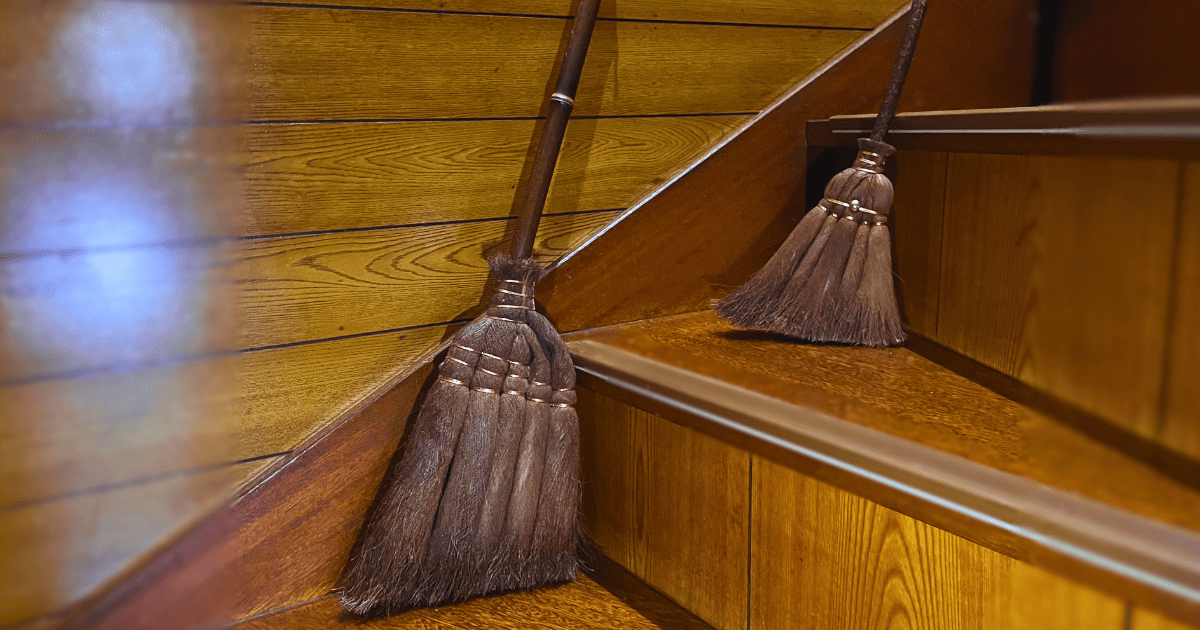 階段に置かれたシュロのほうき2本。静かな掃除時間をともに過ごしてきた愛用品。